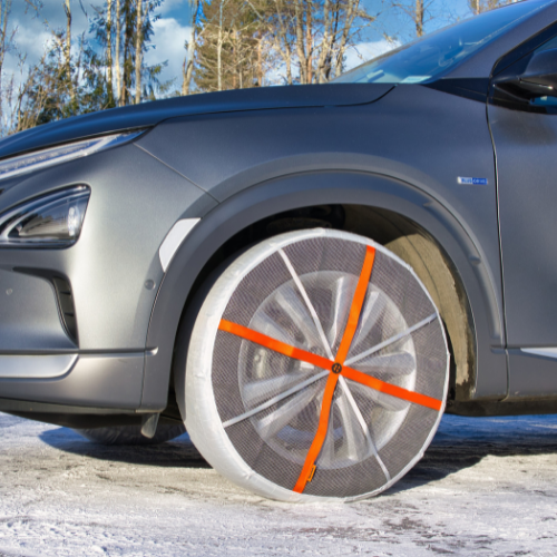 Side view of a car with mounted AutoSock snow socks on front wheels