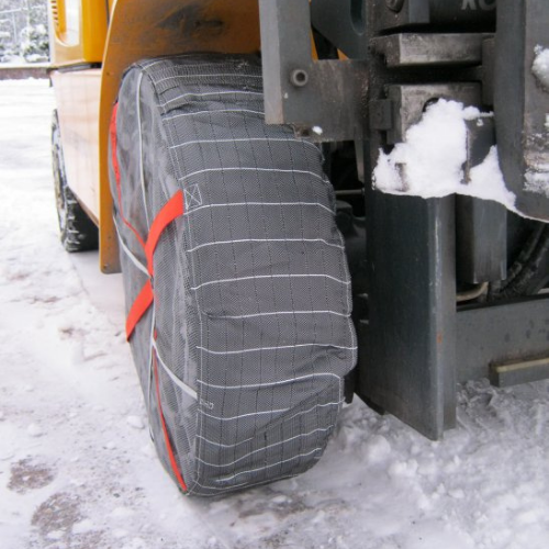 Forklift with mounted AutoSock snow socks on front wheels, standing on snow and ice