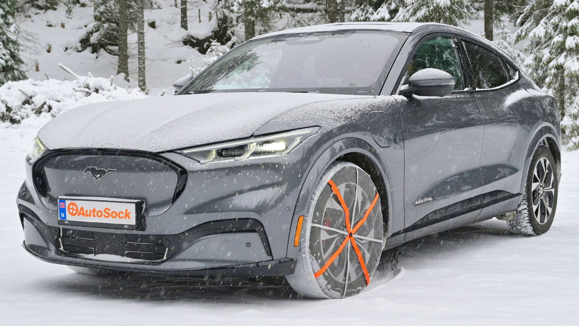 Tekstil snøkjettinger montert på forhjulene til en elbil Ford Mustang